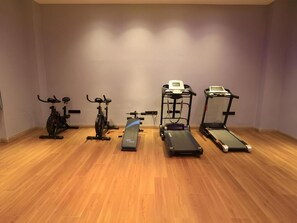 A room with four exercise machines: two stationary bikes, a treadmill, and a stair climber. - Greentree Eastern Xinjiang Aksu Airport Hotel (Wensu County)