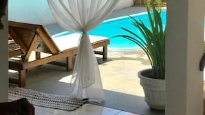 A room with a pool, a bench, and a potted plant. - Pousada Arraial da Poesia (Porto Seguro)