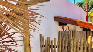 A wooden deck with a white wall and a wooden fence. - Pousada Arraial da Poesia (Porto Seguro)