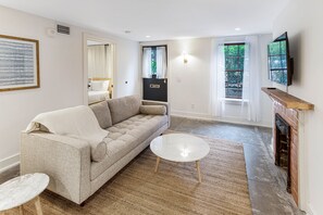 Relax in this cozy space with a sofa, coffee table, and side table, featuring a fireplace and flat-screen TV.