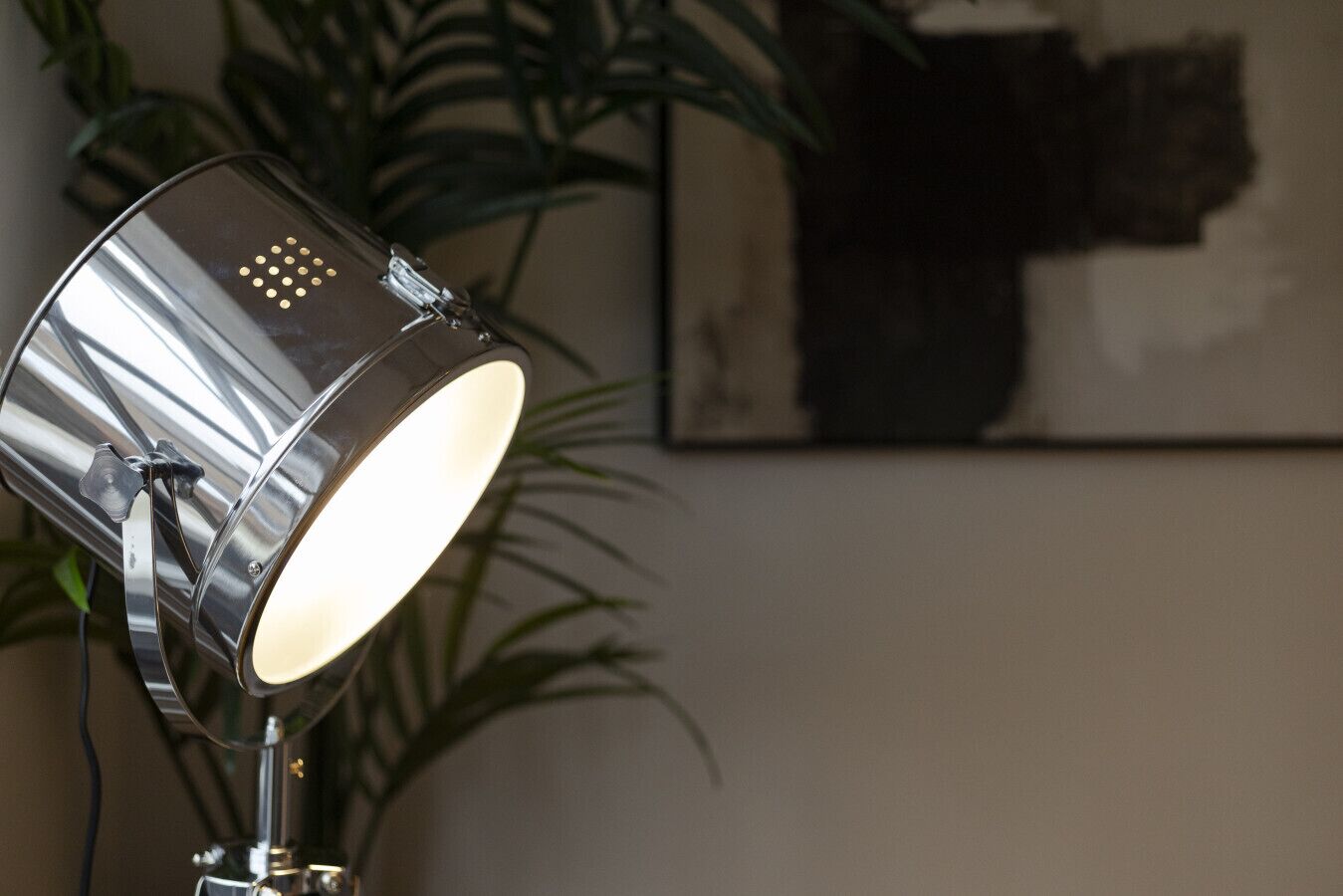 Eine Metalllampe mit spiegelnder Oberfläche und sichtbarer Lichtquelle.