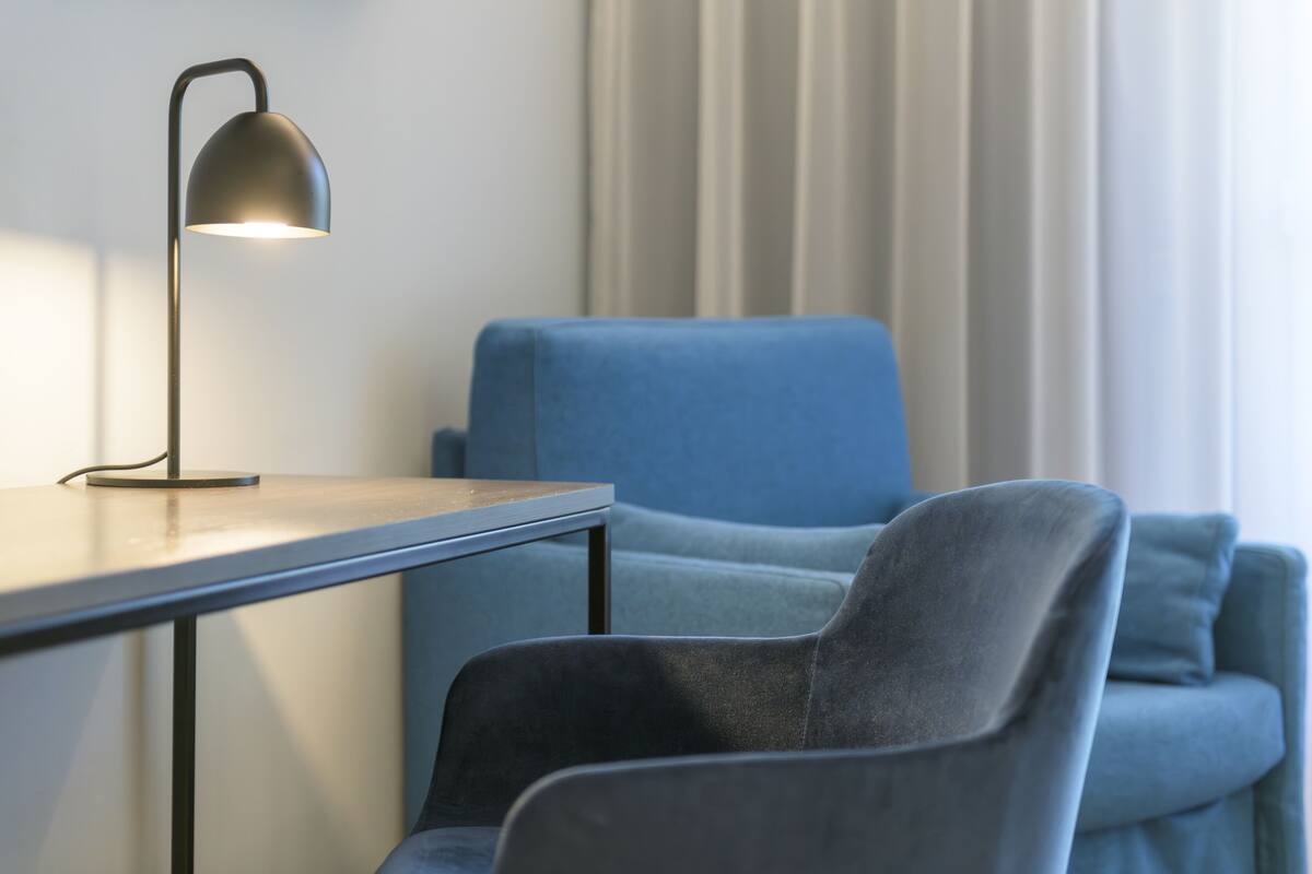 A modern room with a desk and a blue armchair.