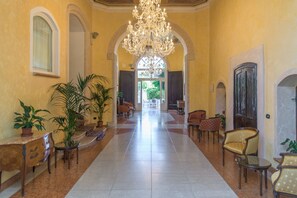 A spacious lobby with a grand chandelier, arched doorways, and comfortable seating areas. - HOTEL REGINA DEL GARDA SUITE (Toscolano Maderno)