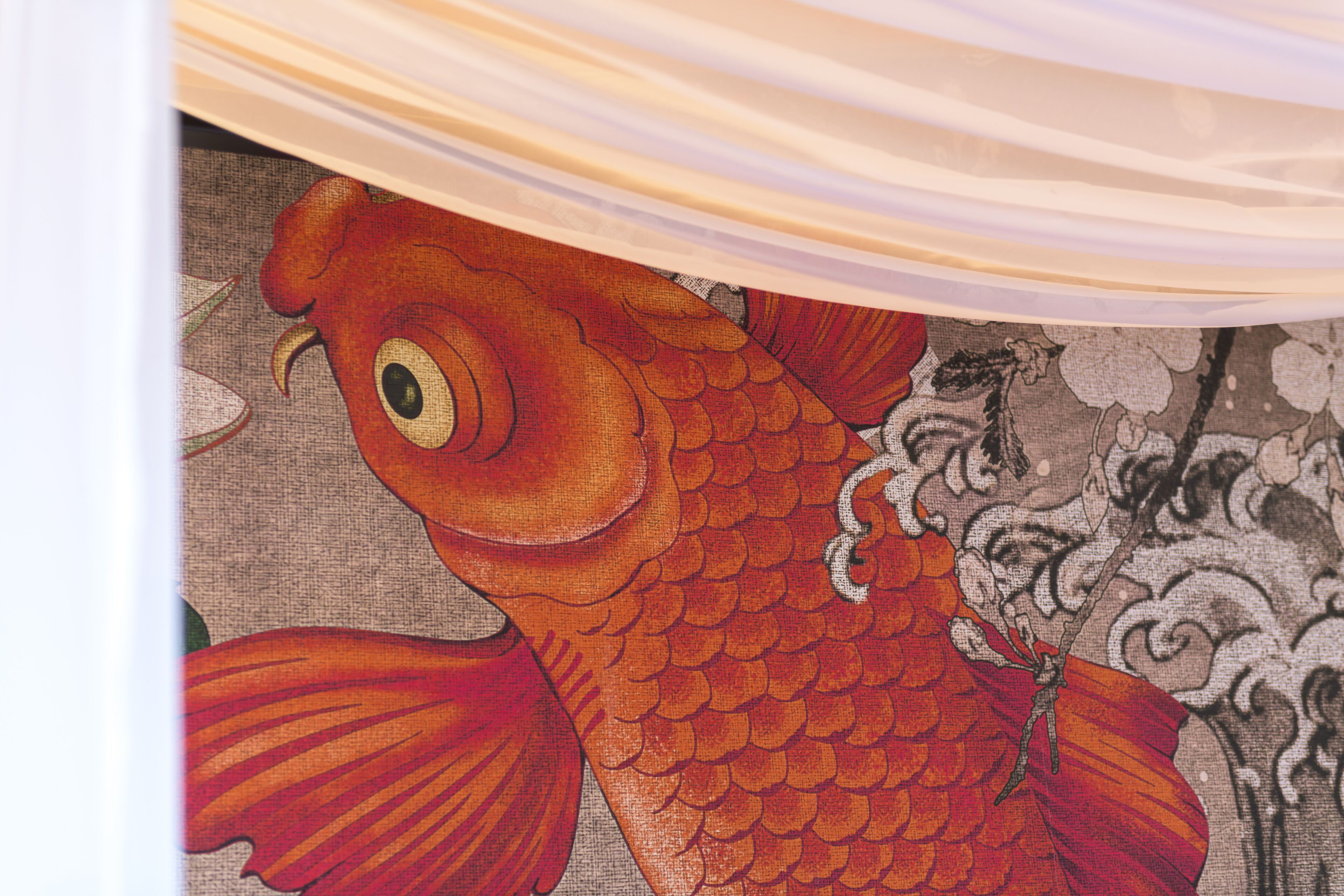 A close-up of a vibrant fish pattern on a fabric, likely part of a larger textile or artwork.