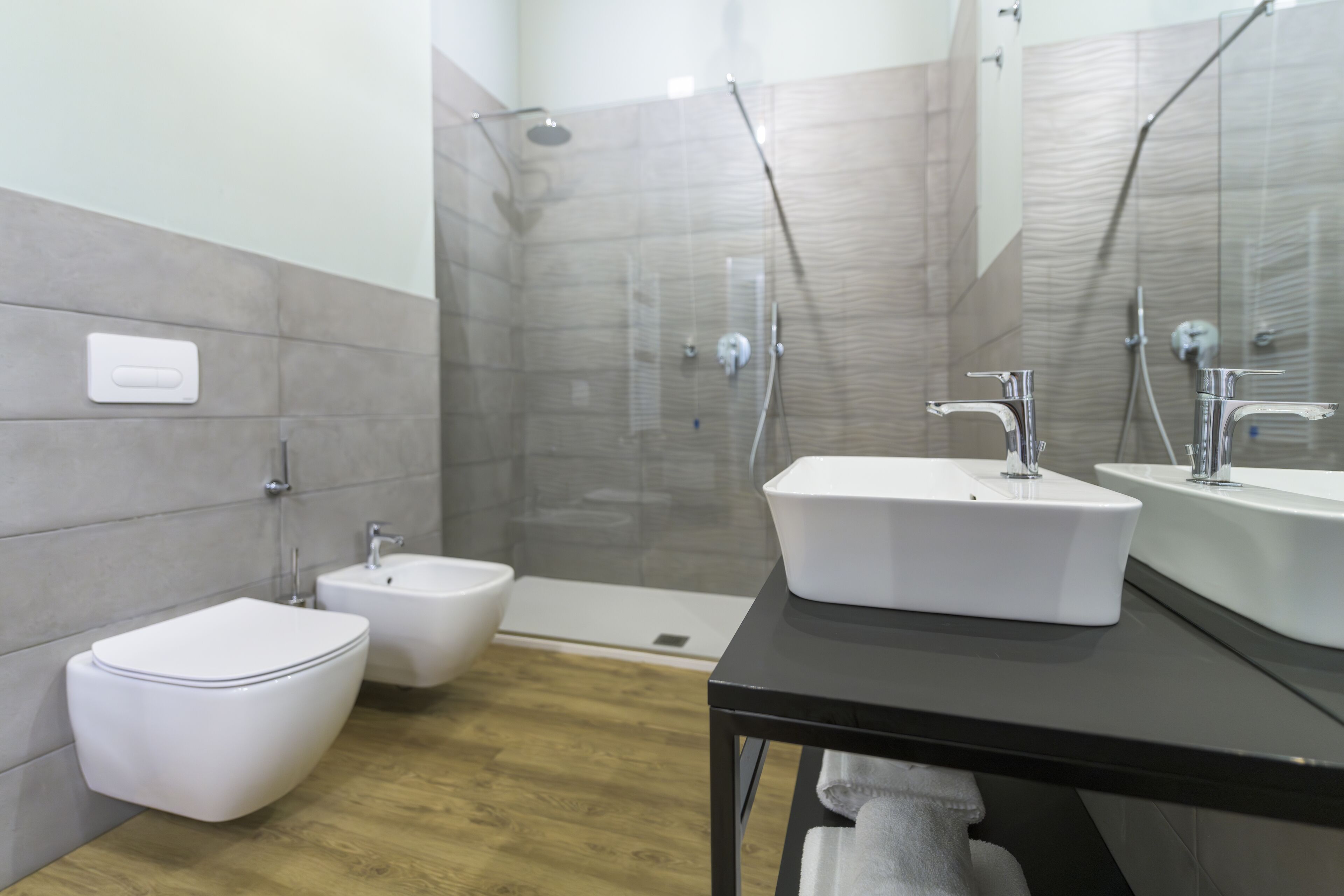 Ein modernes Badezimmer mit Toilette, Bidet und einem großen Waschbecken.