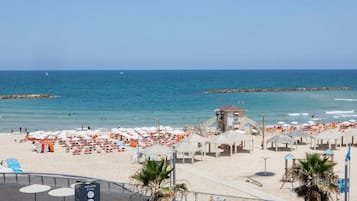 Vlak bij het strand, wit zand, strandlakens, yoga op het strand