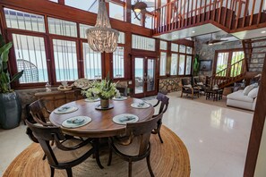 Enjoy meals in this dining area with a large table for six, surrounded by comfortable chairs and offering views of the outdoors.
