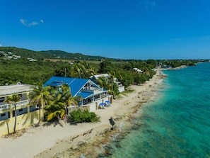 Enjoy a serene beachside retreat surrounded by lush greenery and palm trees.