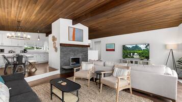 Una sala de estar moderna con chimenea, un sofá, una mesa de centro y un televisor.