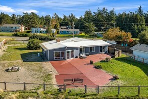 Een modern huis met twee verdiepingen, een ruim terras en een omheinde achtertuin.