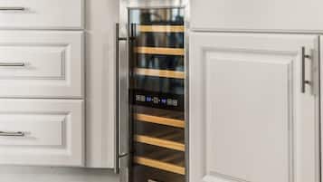 Una cocina con muebles blancos y un electrodoméstico de acero inoxidable con pantalla digital.