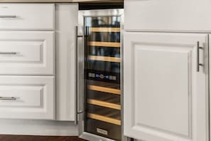 Een keuken met witte kasten en een roestvrijstalen apparaat met een digitaal scherm.