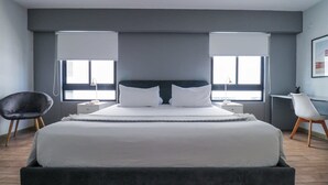 Una camera da letto moderna con un letto grande, due comodini, una scrivania e una sedia.
