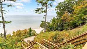 Un escalier en bois mène à une plage d’où l’on a une vue dégagée sur l ’océan.