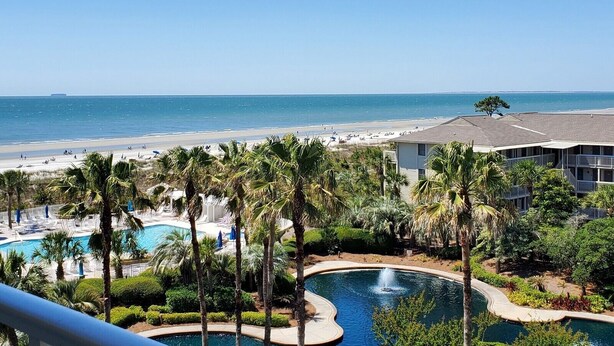 A resort with a pool, palm trees, and a beach view. - Spacious 5th Floor 2 BR Villa w/ Amenities (Hilton Head Island)
