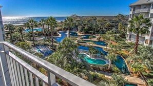 Un complexe hôtelier doté de plusieurs piscines, entouré de palmiers et offrant une vue sur l’océan.