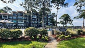 A multi-story residential building with balconies, a gated entrance, and a clear pathway leading to a pool area. - Upscale Villa w/ Panoramic Views of the Sound! (Hilton Head Island)