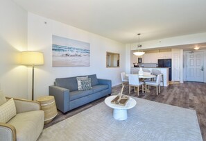 A modern living room with a sofa, a coffee table, and a dining area with chairs.