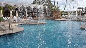 A pool with water jets, lounge chairs, and umbrellas. - The Alexander Resort Ocean Front (Miami Beach)
