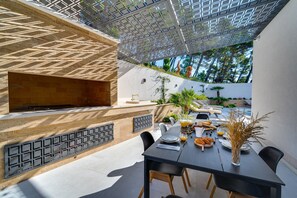 An outdoor dining area with a table set for breakfast, a grill, and a view of the surrounding garden and pool. - Luxury Villa Seventh Heaven with heated pool, hot tub, gym, panoramic views (Klis)