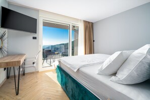 A modern hotel room with a large bed, a desk, and a TV. - Luxury Villa Seventh Heaven with heated pool, hot tub, gym, panoramic views (Klis)