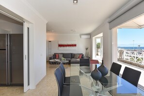 En moderne stue med et glasbord, en sofa og havudsigt.