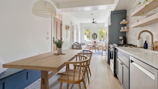 A modern kitchen with a wooden dining table and chairs, a built-in oven, and a white countertop. - Only 2 Blocks to King! | The Murray (Charleston)