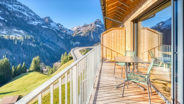 A balcony with a table and chairs overlooking a mountainous landscape. - HUS 23 (Schroecken)