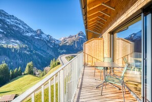 A balcony with a table and chairs overlooking a mountainous landscape. - HUS 23 (Schroecken)