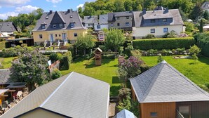 A residential area with multiple houses, a well-maintained garden, and a wooden play structure.