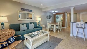 A living room with a sofa, coffee table, and dining area. - Walk to Beach!  Comfortable Chic Hilton Head Villa (Hilton Head Island)