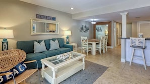 A living room with a sofa, coffee table, and dining area.
