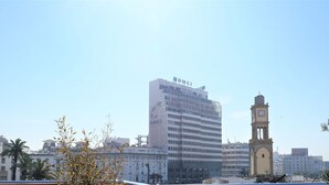 Un paisaje urbano con un edificio BMCI destacado y una torre del reloj.