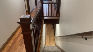 Una escalera de madera con barandilla y peldaños alfombrados que conducen a una plataforma.
