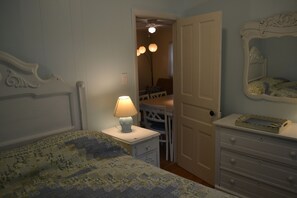 Cozy retreat with a comfortable bed, nightstand, dresser, and mirror.
