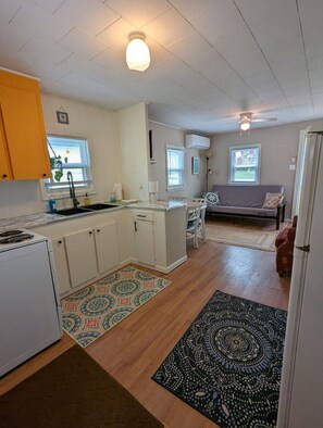 Cozy living space with a kitchenette, dining area, and seating area featuring a sofa and chairs.