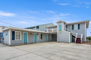 A two-story motel with a balcony and a staircase leading to the upper level.