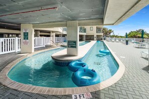 A pool area with a no diving sign, a no glass in pool area sign, and a no eating or drinking in pool sign. - Light & breezy oceanfront condo rental with lazy river, pool, and fitness center near Ocean Drive (North Myrtle Beach)