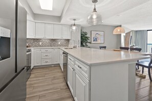 Enjoy cooking in this well-equipped kitchen with a central island, stainless steel appliances, and a double sink.
