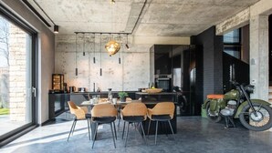 Una cocina moderna con una isla grande, sillas de comedor y una motocicleta.