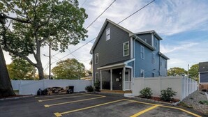 A two-story house with a garage and a driveway marked with yellow lines. - Large 5BR Peaceful House near Perry Beach • Pet-Friendly w/Parking 284 (Quincy)