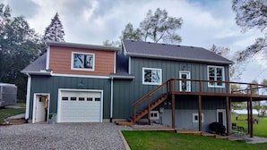 Une maison à deux étages avec un garage, une véranda et un escalier menant à l’étage supérieur.