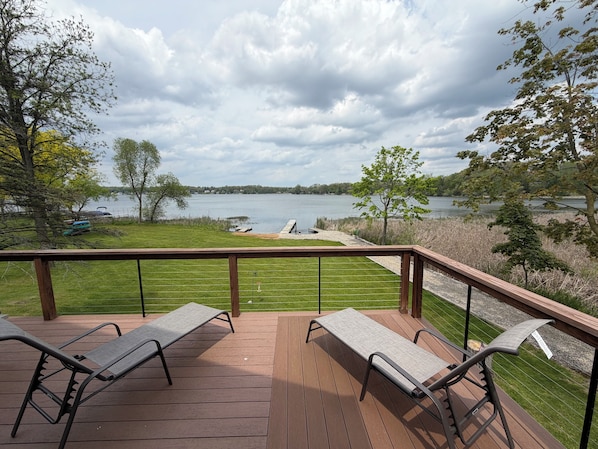 A deck with two lounge chairs overlooking a lake. - The Cheerful Lake House at Crane Cove (Jackson)