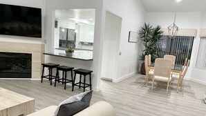 Ein modernes Wohnzimmer mit Sofa, Couchtisch und Essbereich mit Tisch und Stühlen.