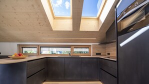 Una cucina moderna con lucernari, mobili scuri e un piano di lavoro in legno.