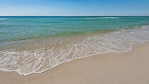 A beach with clear water and a sandy shore.
