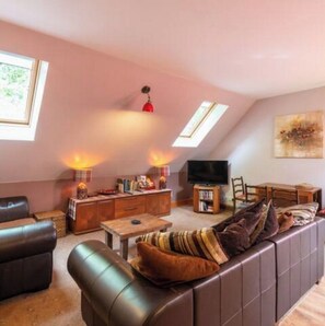 Relax in this inviting living room with a comfortable sofa, dining area, and fireplace.