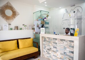 A reception area with a glass display case, a reception desk, and a yellow sofa.