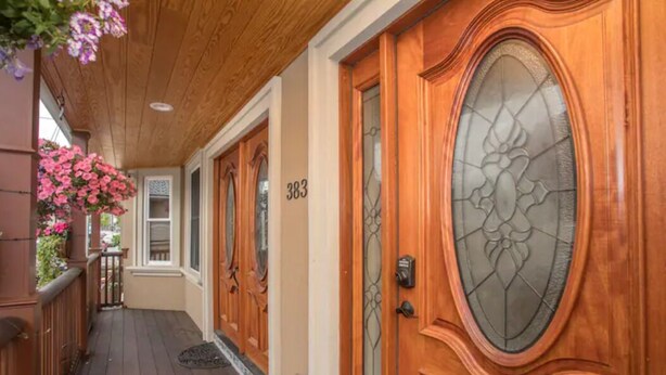 Puerta de madera con un panel de vidrio y el número 383.