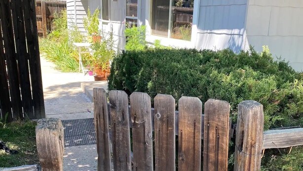 A wooden fence with a metal gate, a house with a window, and a small garden area. - Adventurer's Paradise 🏔 ⛷ Close to Boulder/Denver (Lafayette)
